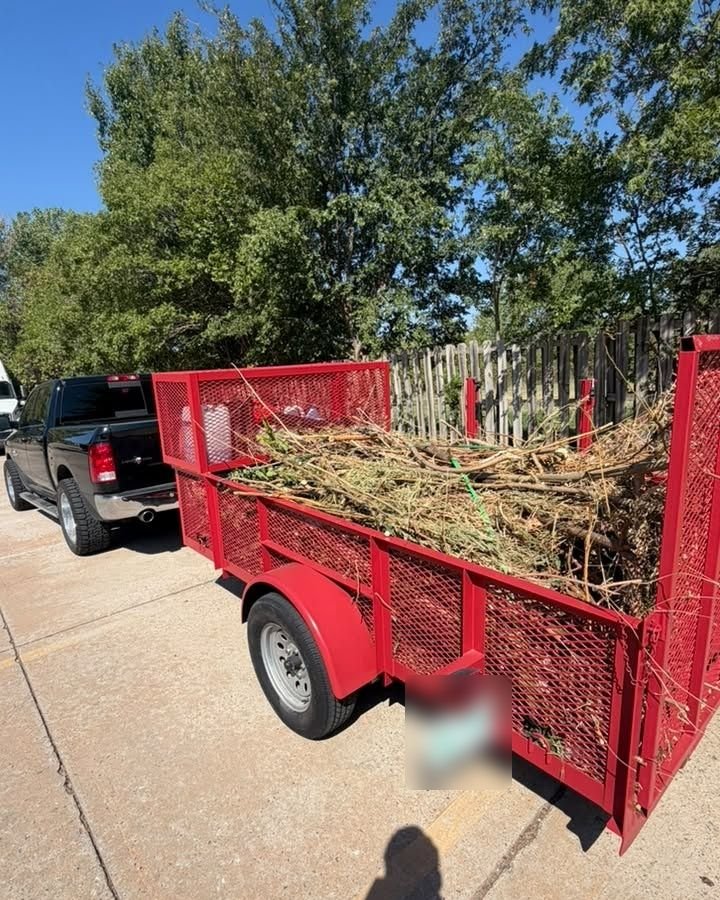 Red trailer loaded with brush and limbs for hauling