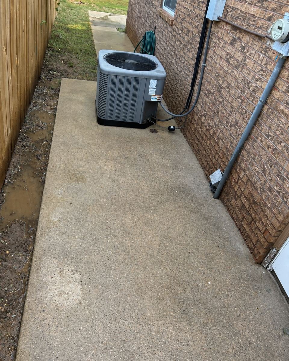 Side yard by the AC unit after a drainage fix and walkway cleanup