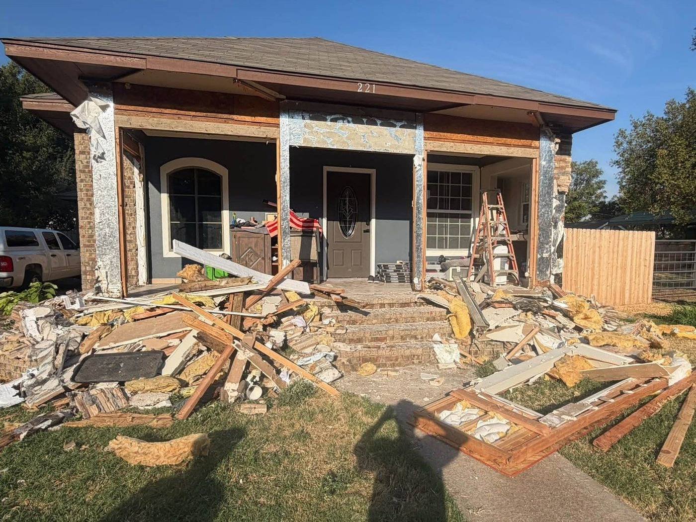 Before: front porch covered in demolition debris, boards and insulation