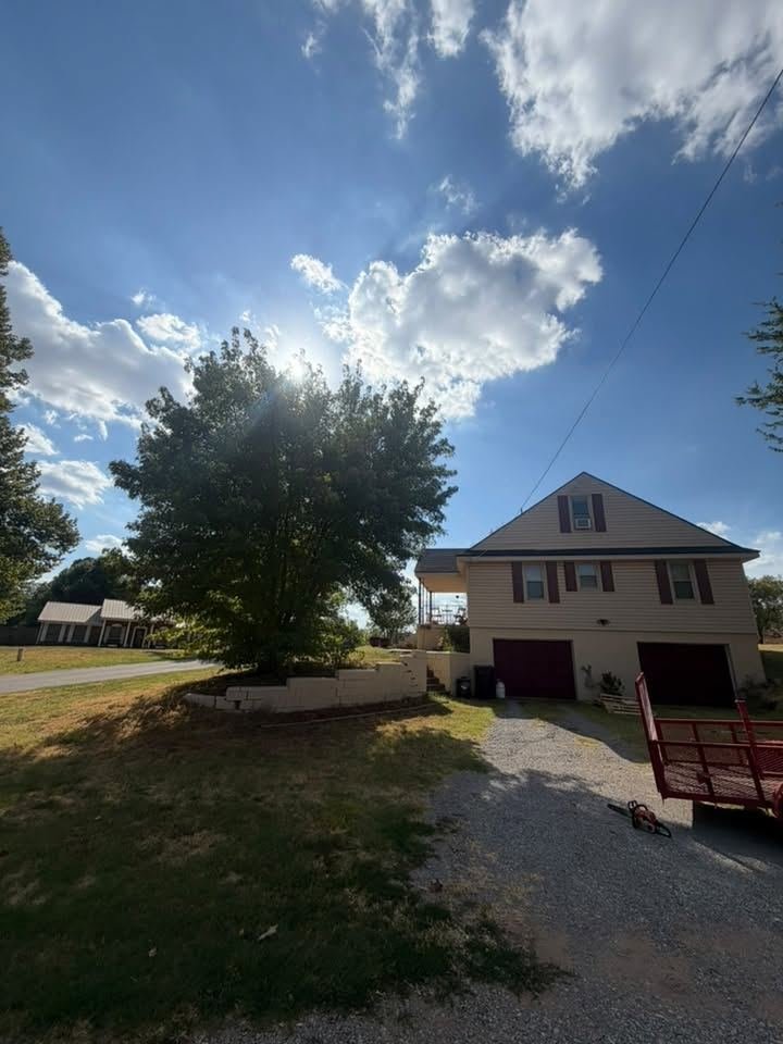 Before: large tree beside the house and driveway